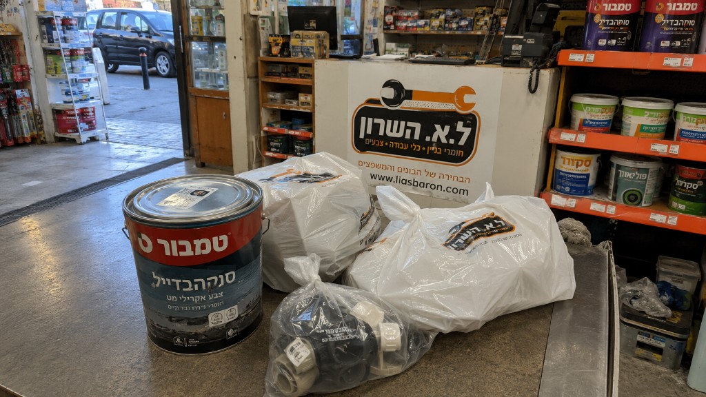 איסוף עצמי מהיר — הזמנה מוכנה בדלפק ל.י.א השרון עם שקיות, דלי טמבור וחומרי בניין